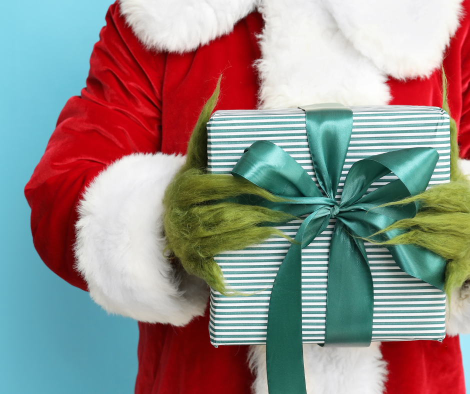 Grinch holding a holiday present.