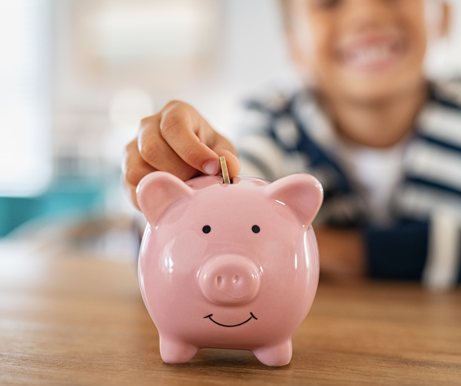 Child putting money into piggy bank
