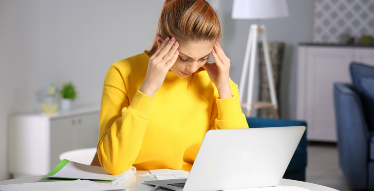 Lady with yellow shirt on laptop confused about credit scores