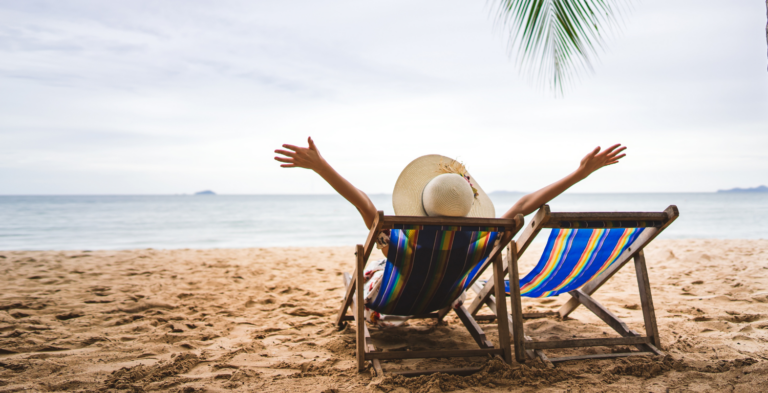Women in a beach chair celebrating being on vacation