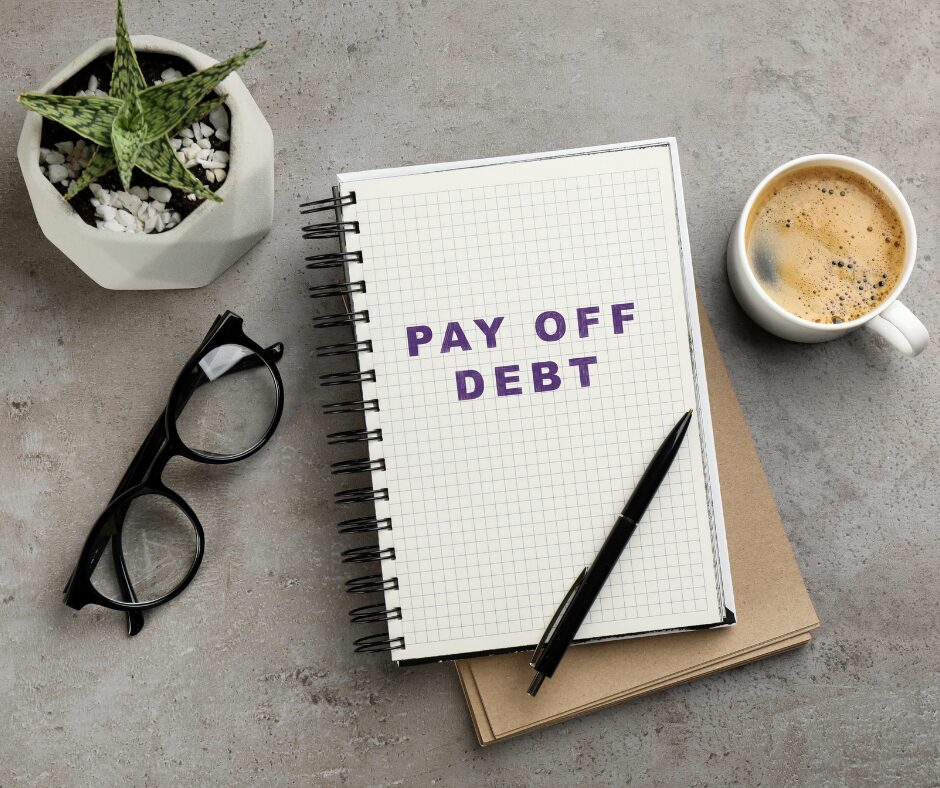 Notebook with Pay off debt wrote on it