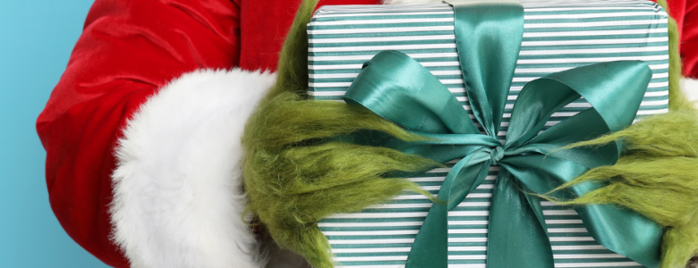 Grinch holding a holiday present.